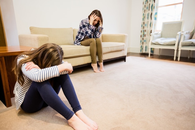 Malestar madre e hija sentada en la sala