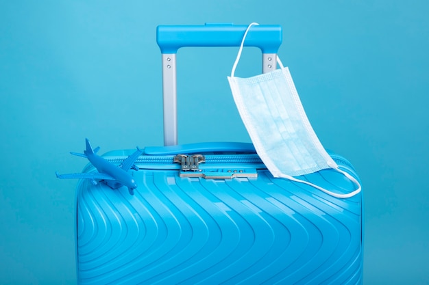Foto gratuita maleta azul para viajar con mascarilla médica.