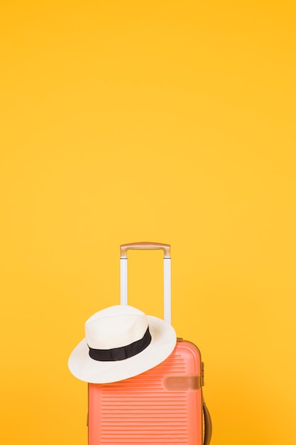 Maleta naranja y sombrero blanco