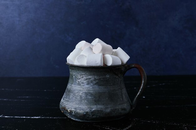 Malvaviscos blancos en una taza metálica