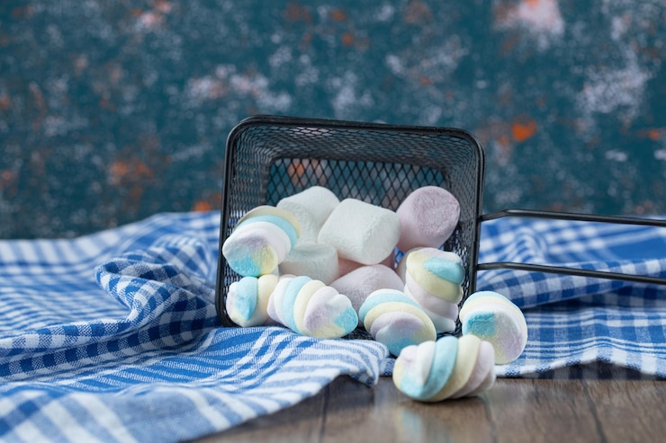 Foto gratuito malvaviscos deliciosos multicolores en mini canasta metálica.