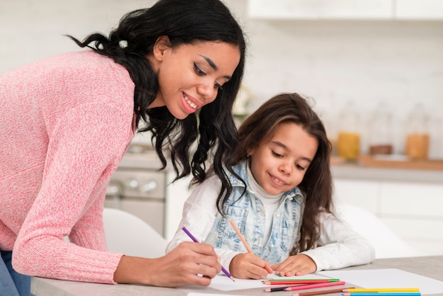 Mamá ayudando a hija a colorear