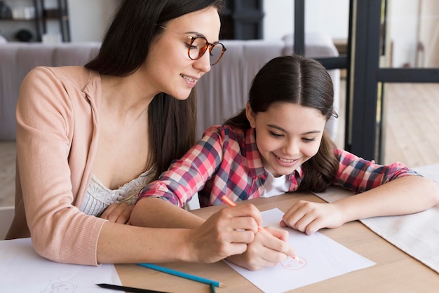 Mamá ayudando a hija a dibujar