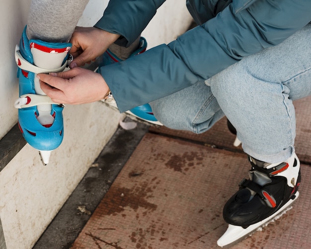 Mamá ayudando a hija con patines de hielo