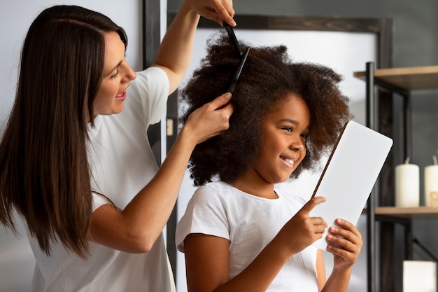 Mamá ayudando a su hijo a peinar el cabello afro