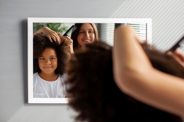 Foto gratuita mamá ayudando a su hijo a peinar el cabello afro