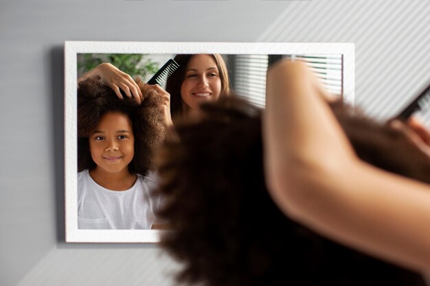 Mamá ayudando a su hijo a peinar el cabello afro