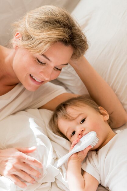 Mamá y bebé sentado en la cama