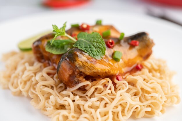 Mamá y conservas de pescado en un plato blanco.