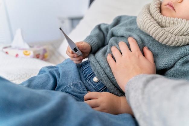 Mamá cuidando a su hijo y teleconsultando con el médico