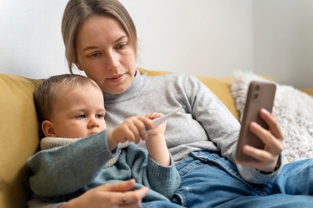 Mamá cuidando a su hijo y teleconsultando con el médico