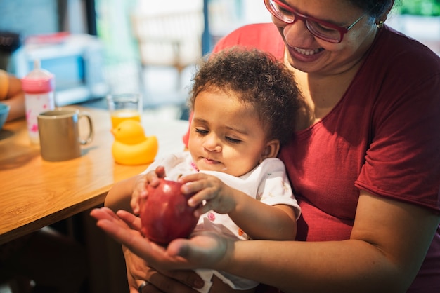 Mamá dejando que su hija juegue con manzana