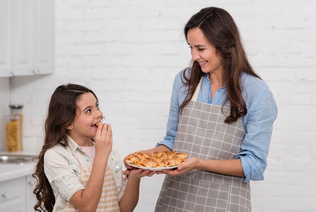 Mamá e hija comiendo deliciosos pasteles