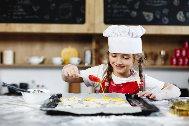 Mamá e hija se divierten preparando galletas con leche en una mesa en una cocina acogedora