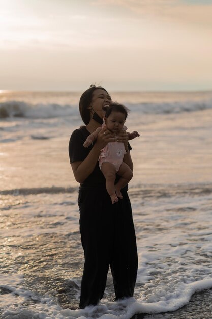 Mamá e hija recién nacida en la playa