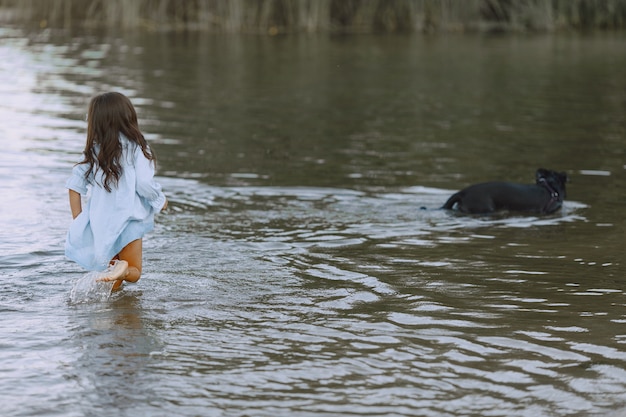 Mamá e hija con vestidos idénticos. Familia jugando junto al río.