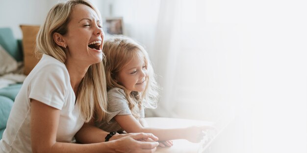 Mamá e hija viendo una caricatura en una tableta digital