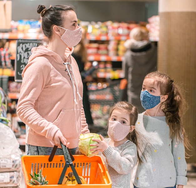 Mamá e hijas compran máscaras en la tienda durante la cuarentena debido a la pandemia de coronavirus.