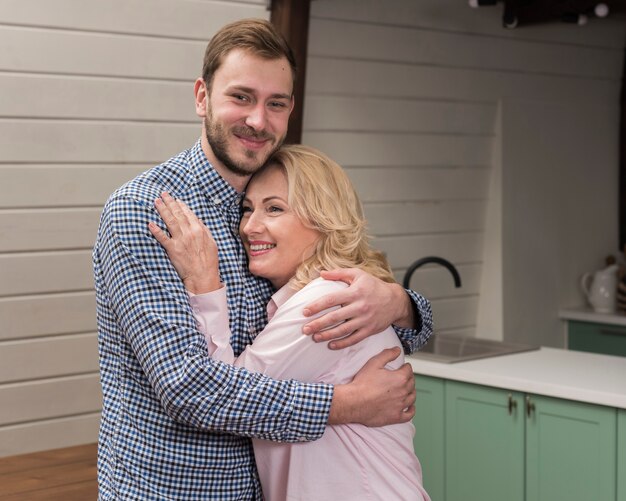 Mamá e hijo abrazados en la cocina