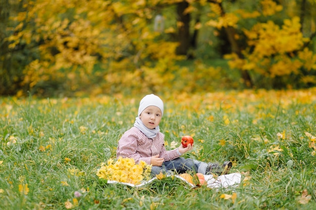 Mamá e hijo caminando y divirtiéndose juntos en el parque de otoño.