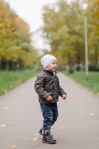 Mamá e hijo caminando y divirtiéndose juntos en el parque de otoño.