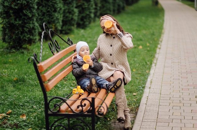 Mamá e hijo caminando y divirtiéndose juntos en el parque de otoño.