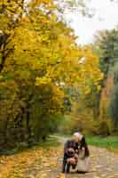 Foto gratuita mamá e hijo caminando y divirtiéndose juntos en el parque de otoño.