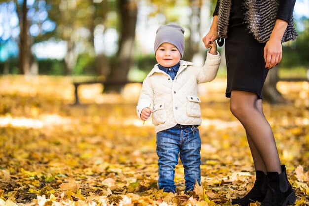 Mamá e hijo caminando en un parque de otoño