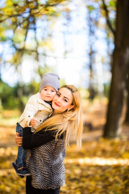 Mamá e hijo caminando en un parque de otoño