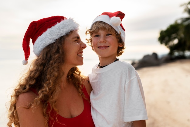 Foto gratuita mamá e hijo celebrando la navidad en julio.