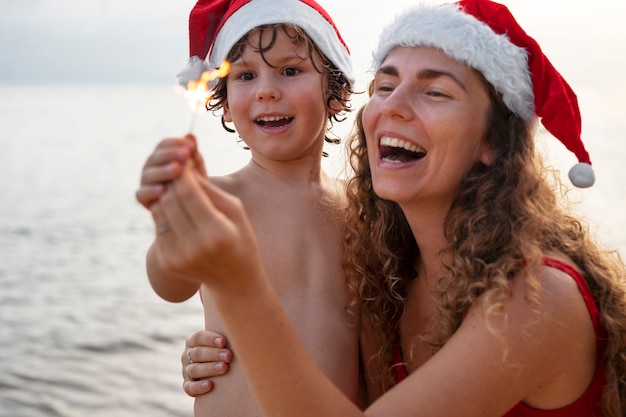 Foto gratuita mamá e hijo celebrando la navidad en julio.