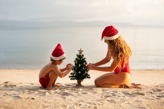 Foto gratuita mamá e hijo celebrando la navidad en julio.