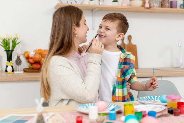 Mamá e hijo pintando huevos para pascua