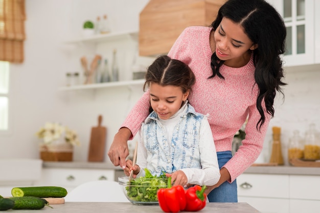 Mamá enseñando a hija a cocinar