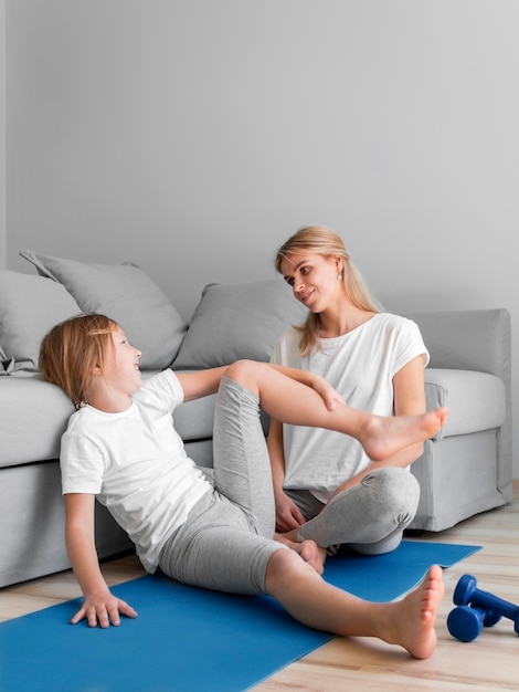 Mamá con entrenamiento de niña en estera