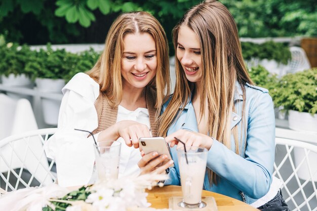 Foto gratuita mamá y hija se divierten en el café y hablan.