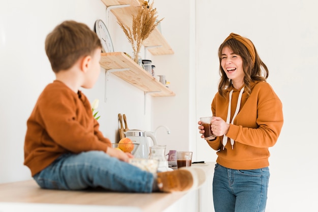 Foto gratuita mamá con hijo en la cocina disfrutando el tiempo juntos