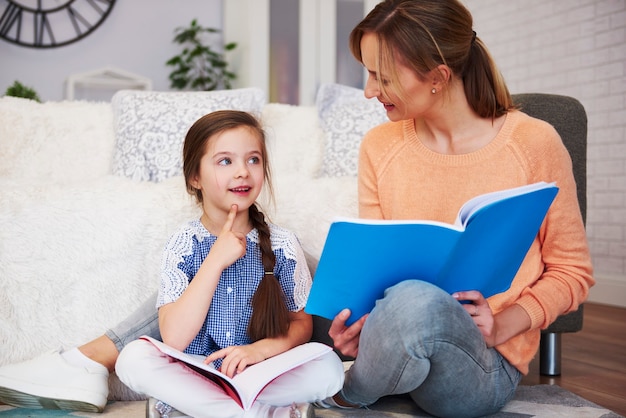 Mamá joven ayudando a su hija con la tarea