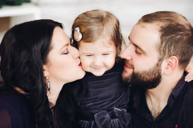 Foto gratuita mamá joven hermosa con el pelo largo y ondulado negro, papá fuerte atractivo con el pelo corto y oscuro y un niño