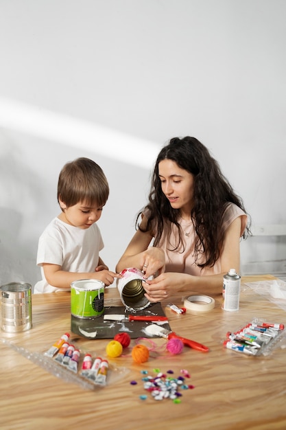 Mamá le muestra a un niño cómo reutilizar materiales de manera creativa