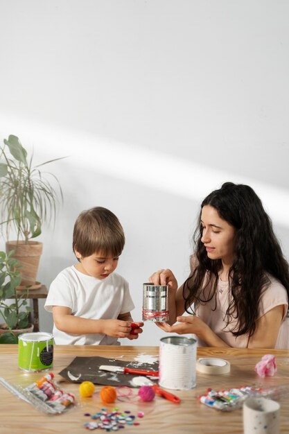 Mamá le muestra a un niño cómo reutilizar materiales de manera creativa