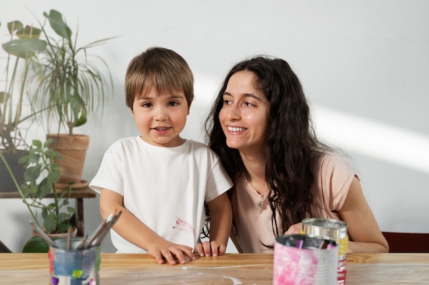 Foto gratuita mamá le muestra a un niño cómo reutilizar materiales de manera creativa