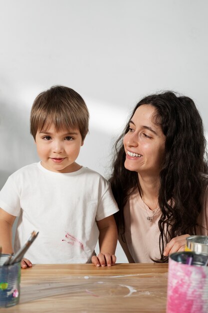 Mamá le muestra a un niño cómo reutilizar materiales de manera creativa