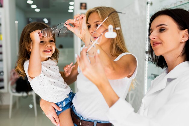 Mamá y niña buscando monturas de gafas