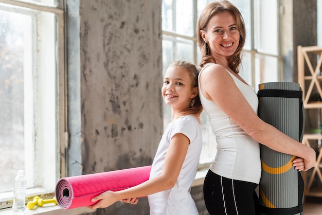 Mamá y niña con colchonetas de yoga