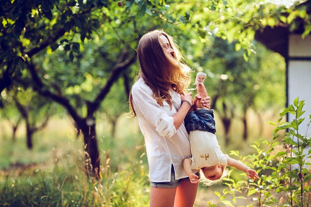 Mamá y niña divirtiéndose en el jardín.