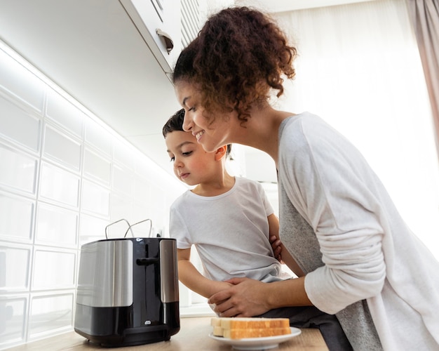 Mamá y niño esperando pan tostado