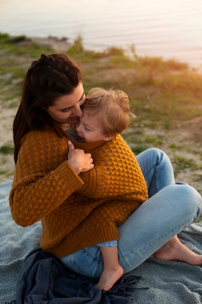 Foto gratuita mamá pasa tiempo con su hijo en la playa