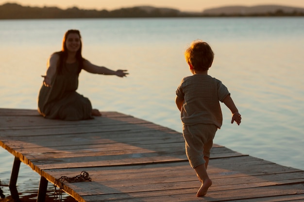 Foto gratuita mamá pasa tiempo con su hijo en la playa