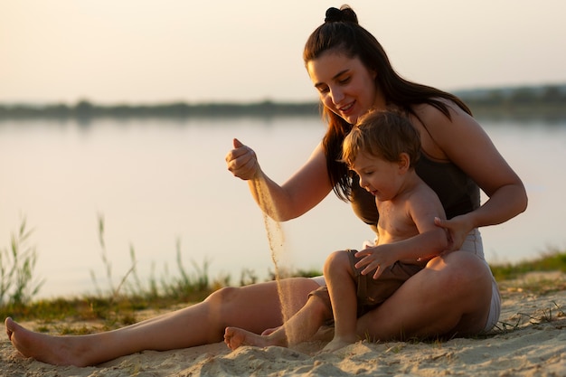 Foto gratuita mamá pasa tiempo con su hijo en la playa